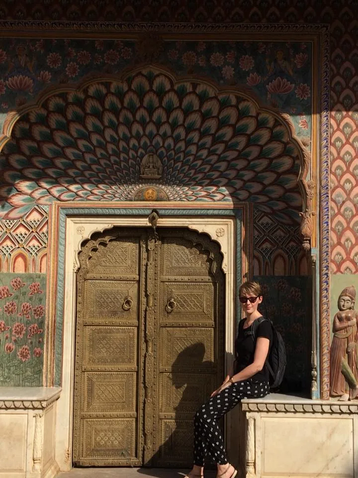 Guest exploring a painted doorway in Jaipur